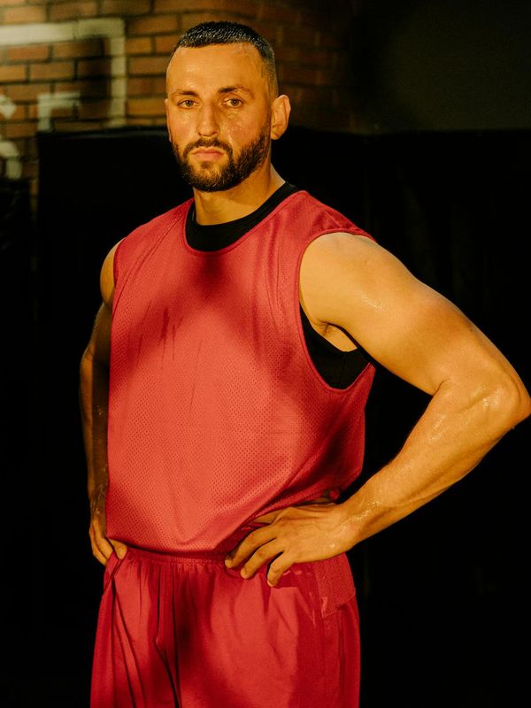 Athletic man performing gentle strength exercises in dark room